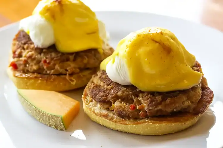 Crab Cake Benedict with poached eggs and hollandaise sauce on an English muffin.
